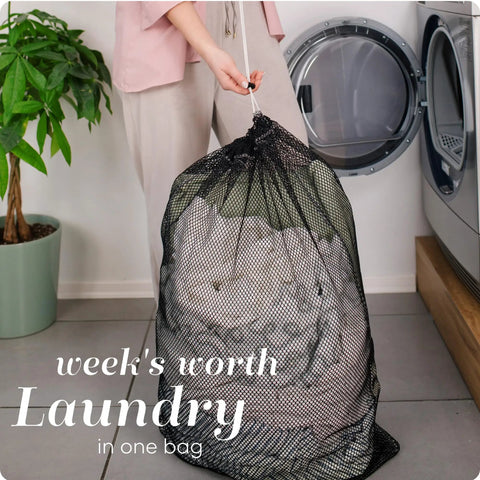 Heavy Duty Mesh Laundry Bag Large 24 By 36 With Secure Drawstring Closure in use, filled with clothes in front of a dryer