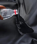 Water being poured on Waterproof Front Car Seat Cover Protector Universal Fit For Cars And Trucks Easy Install Reusable Black Seat Protector.