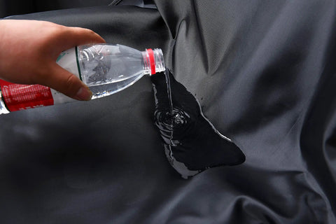 Water being poured on Waterproof Front Car Seat Cover Protector Universal Fit For Cars And Trucks Easy Install Reusable Black Seat Protector.