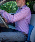 Man using Teeter Core Restore Inflatable Lumbar Support Cushion in car for back pain relief and posture correction.