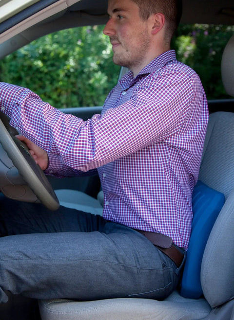 Man using Teeter Core Restore Inflatable Lumbar Support Cushion in car for back pain relief and posture correction.