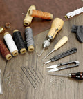 All-In-One Leather Sewing Kit With Waxed Thread, 40-Piece Awl Set, Extra Awls, 24 Leather Needles, Seam Ripper on wood surface.