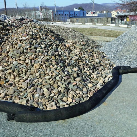 Sediment Filter Sock for Erosion Control and Storm Drain Protection, black sock, surrounds gravel pile, flexible design visible