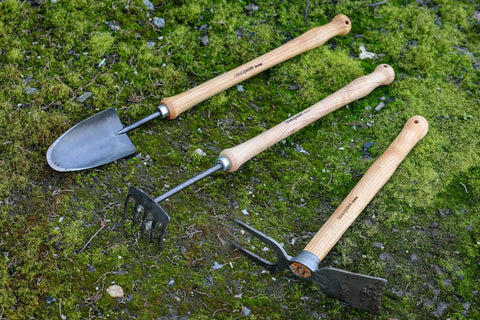 Beefy Dual Function Hand Mattock With Hoe Blade And Grubber For Small Garden Trenching And Root Cutting 15.5 Inch tools on grass.