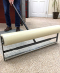 Carpet Protection Film 36 Inch By 500 Foot Floor And Surface Shield With Sticky Backing being applied using a rolling tool.
