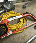 12 Inch Fast Tension Hacksaw With Dual Material Handle, On Board Blade Storage, and metal pipes in a workshop setting