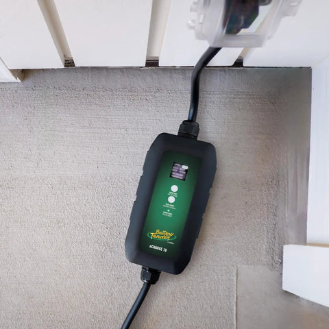 Dead Simple 16 Amp Level One Portable Ev Charger with green LCD screen and connector plugged into an outlet.