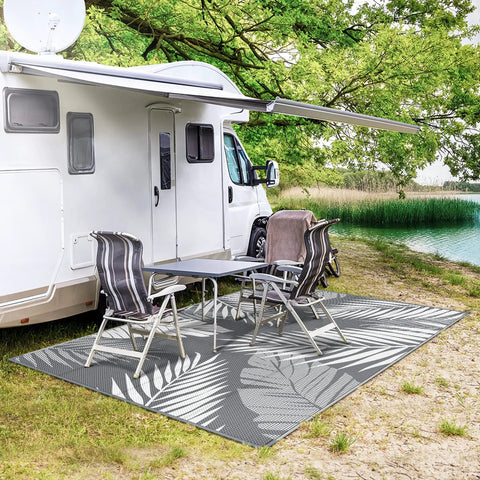 Waterproof Outdoor Rug 5x8 Feet Double-Sided Palm Leaf Pattern Grey And White Plastic Patio Mat by an RV near a lake