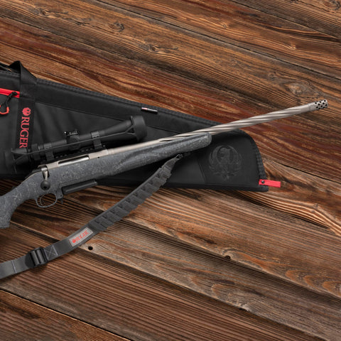 Rifle on a wooden surface with a Baktrak Traction Web Rifle Sling 36 Inch With 500 Pound Swivels, Slim Non Slip Pad attached.