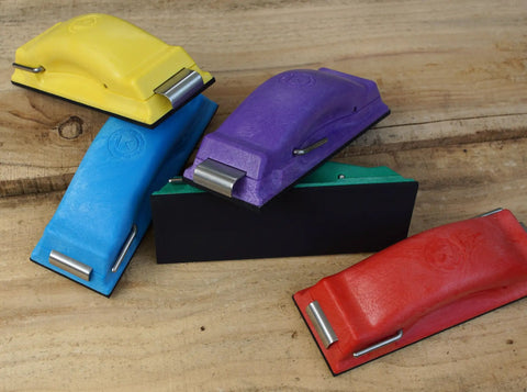 Colorful ergonomic sanding blocks for wet or dry sanding, showcasing yellow, blue, green, purple, and red with easy load feature.