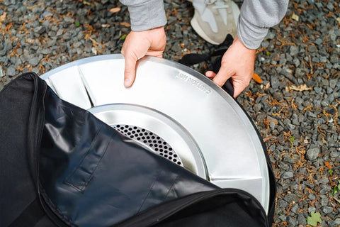 Person placing heat deflector into Medium Heat Deflector Carry Bag For Bonfire Accessories Weather Resistant Protective Gear Case