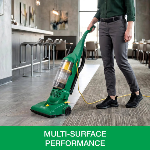 Heavy Duty Bagless Upright Vacuum Chomping Debris On Carpets Hardwood Floors And Furniture With Beastly Suction Plus Onboard Tools and Commercial Filtering For Daily Grind Cleaning in use on tiled flooring.