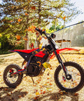 Gnarly 2600W Mid-Drive Electric Dirt Bike For Teens And Adults Up To 40 MPH With 23.4Ah 48V Battery Dual Hydraulic Brakes Front And Rear Suspension Red on forest trail.