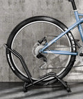 Heavy Duty Indoor Bike Floor Stand Adjustable Single Wheel Rack For Garage Ready Setup Fits 16 To 29 Inch Wheels next to a wall