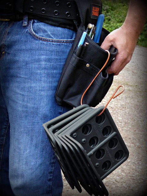 Box Of Fifty H2 Homer Helpers For Electrical Wire Management held in hand, with various tools in belt pocket.