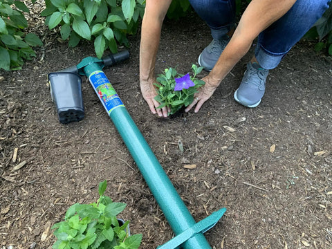 Woman planting with Five In One Lawn And Garden Tool For Easy Planting And Weeding Bulb Planter Sod Plugger Weeder Annual Planter And Soil Tester Dig Two One Eighth Inch Holes Quickly From A Comfortable Standing Position No Bending Over With Soil Storage.