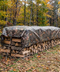 Wood pile covered by No Nonsense Tough 9 Mil Tarp Cover Waterproof UV Resistant Tarpaulin for outdoor use in a forest setting.