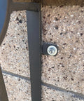 Close-up of mounted metal part using Heavy Duty Welding Tabs 50 Pack For DIY Pros on stone wall with bolt connection.