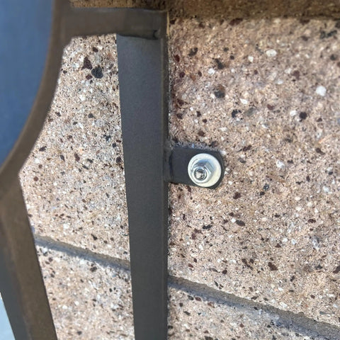 Close-up of mounted metal part using Heavy Duty Welding Tabs 50 Pack For DIY Pros on stone wall with bolt connection.