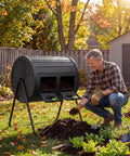 Man using Dual Chamber Compost Tumbler 37.5 Gallon Outdoor Bin BPA Free Rotating Composter With Two Lockable Doors in garden