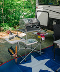 Portable Grill Table With Tons Of Prep Space For Camping, Tailgating, Picnics, And Boating set up by RV with grill and utensils