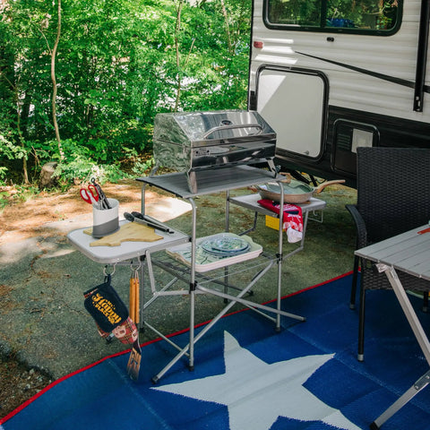 Portable Grill Table With Tons Of Prep Space For Camping, Tailgating, Picnics, And Boating set up by RV with grill and utensils