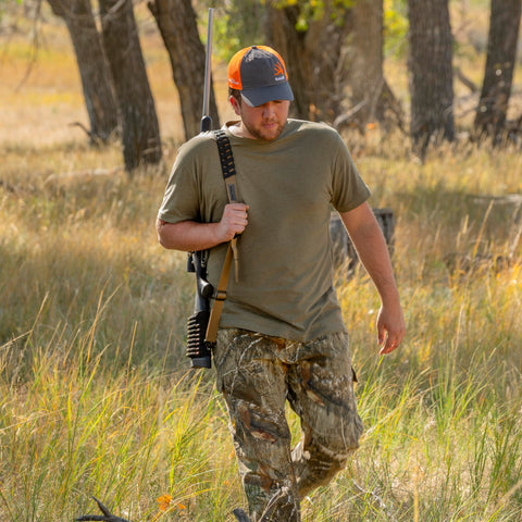 Hunter using Baktrak Traction Web Rifle Sling 36 Inch With 500Lb Swivels Slim Non Slip Pad Tan Black for easy carry.