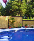 Natural Bamboo Fence Roll Panel 0.75 Inch Thick 6 Foot High By 8 Foot Long used as poolside privacy fence with plants