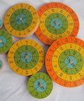 Eight hardwood disks of a three dimensional periodic table display with element symbols, atomic numbers showing orbital symmetry.