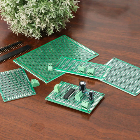 40 Pack Prototyping Printed Circuit Boards Kit With Five Size Universal Perforated Solderable Proto Boards For DIY Electronics Projects Plated Through Holes For Easy Soldering displayed on a wooden surface with electronics components installed.