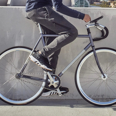 Side view of person on bike using Toe Clips For Bike Pedals With Wide Opening For Easy On Off Comfort And Convenience Durable Foot Straps