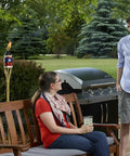 Heavy Duty Cast Iron Torch Stand Built Like A Tank For Outdoor Lighting beside couple on patio, freestanding base visible