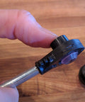 Hand holding Universal Automatic Transmission Shift Cable Bushing Repair Kit Replacement Shifter Bushing on metal rod