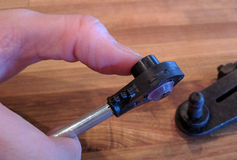 Hand holding Universal Automatic Transmission Shift Cable Bushing Repair Kit Replacement Shifter Bushing on metal rod