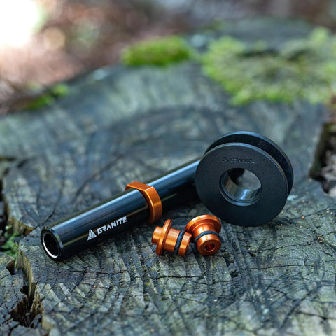 Dummy Hub Axle Chain Keeper For 12mm Thru Axle And QR Frames, black and orange pieces on a wooden surface