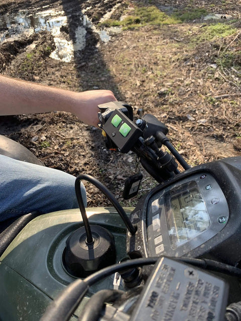AXR1 Water-Resistant 3-Button Remote For Automatic Gate Openers mounted on ATV handlebar during outdoor use