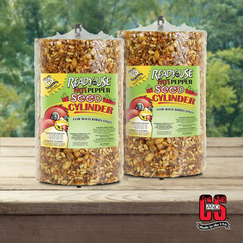 Hot Pepper Bird Seed Cylinder Two Pack Ready To Use No Fuss With Hanging Feeder Mount For Outdoor Wild Birds 1.76 Lb Each Squirrel Deterrent Spicy Formula Keeps Squirrels Away Without Harming Birds displayed on wooden background