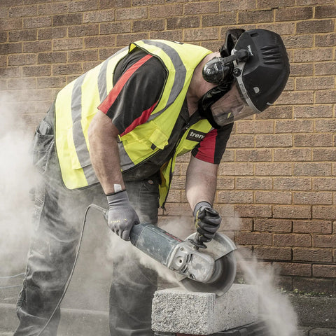 Man using Badass Powered Air Respirator And Hearing Protection Bundle For Woodworking Shops Featuring Full Face Impact Shield Heavy Duty Dust Filters And Integrated Ear Guards Built Tough For Sanding Routing And Turning on a concrete block.