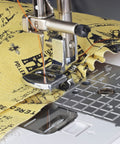 Front view of silver sewable shirring gathering presser foot on a low-shank sewing machine with yellow printed fabric.
