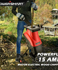 Person using Electric Wood Chipper Shredder with 15 Amp Motor and Collection Bag for Easy Yard Cleanup Ultra Quiet Workhorse Brushless Power Built to Last Handles Branches Up to 1 5/8 Inches for Composting PS10 in a garden setting.