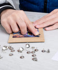 Person using Real Solid Silver Flat Head Thumb Tacks And Push Pins With Slick Low Profile Design for crafts on a board.