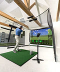 Golfer using Indoor Golf Practice Net With 10x8 Ft Hitting Net And Impact Screen setup in home with simulator screen