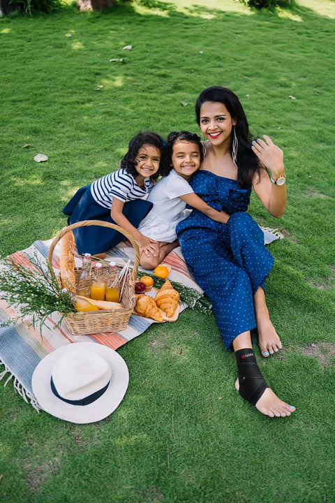 Woman wearing ankle brace for women and men with compression foot support at a picnic with kids, medium size, grass background