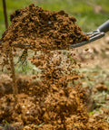 Pro-Lite Ergonomic Carbon Steel Digging Fork lifting soil, showcasing lightweight garden tool with extra-wide step in action, red handle.