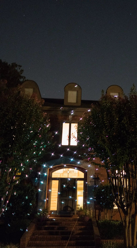 Motion Snow Fall Light Show With White Laser And 7 Color Star Effects Christmas Lights illuminating a house exterior at night