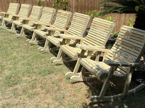 Row of unfinished wooden rocking chairs in a backyard, crafted using Dead Easy Outdoor Rocking Chair Plans With Smooth Ride Precision Mdf Templates And Goof Proof Step By Step Guide For Ultimate Backyard Kickback Lounge Made In Usa.