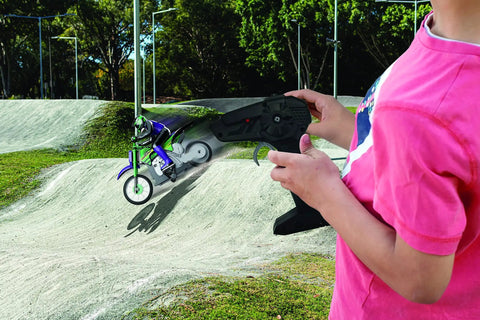 Child using ergonomic remote for Crosslander RC18 Electric Motocross Bike With 2.4 GHz Radio Control Up To 12 Kmph Speed on dirt track