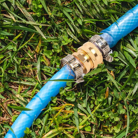 Premium One Half Inch Aluminum Hose Repair Connector Kit With Stainless Steel Clamp connecting two blue garden hoses on grass
