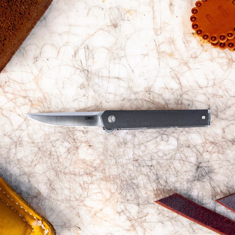Compact EDC Pocket Folding Knife With Liner Lock Black Finish Slick Flipper Deployment IKBS Ball Bearing Pivot High Carbon Stainless Steel Blade Lightweight Glass Reinforced Nylon Handle Easy Sharpening Everyday Carry Ready open on textured mat