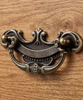 Antique Brass Drop Bail Drawer Pulls 3.5 inch center to center with vintage cabinet pulls on wooden dresser.